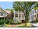 Charming two-story home featuring a welcoming front porch, mature tree, and lovely landscaping at 1626 Gilstrap Nw Ln, Atlanta, GA 30318
