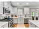 Bright kitchen with stainless steel appliances, white cabinets, and wood flooring for a modern and clean look at 1626 Gilstrap Nw Ln, Atlanta, GA 30318