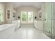 Bright bathroom with double vanities, a soaking tub, and a glass-enclosed shower at 172 Olympic Pl, Decatur, GA 30030