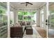 Inviting sunroom with brick floors, tile wall, seating and large windows overlooking the backyard at 172 Olympic Pl, Decatur, GA 30030