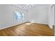 Clean and bright room with hardwood flooring, natural light, white walls, and modern ceiling fixture at 1965 Tiner Ct, Cumming, GA 30041