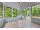 View of a screened-in porch featuring tiled flooring, wooded views, and an exterior shed at 1965 Tiner Ct, Cumming, GA 30041