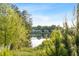 Scenic view of a tranquil pond surrounded by lush greenery and beautiful homes in the background at 2208 Sage Mountain Sw Ct, Marietta, GA 30064