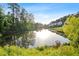 Picturesque pond surrounded by green trees, reflecting the sky and nearby houses at 2208 Sage Mountain Sw Ct, Marietta, GA 30064