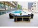 Community pool with modern patio furniture in an inviting outdoor setting, surrounded by condo buildings at 890 Memorial Se Dr # 102, Atlanta, GA 30316