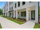 New townhouse exterior with white painted brick, black window trim, and manicured lawn at 2200 Carlton Ct # 6, Atlanta, GA 30318
