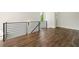 Upstairs hallway featuring wood floors and black metal railing with access to another room at 2200 Carlton Ct # 6, Atlanta, GA 30318