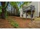 Backyard view showcasing a home with a deck and a natural, wooded landscape at 7035 Hampton Bluff Way, Roswell, GA 30075