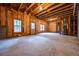 Unfinished basement with exposed wood beams, insulated walls and multiple windows at 7035 Hampton Bluff Way, Roswell, GA 30075