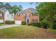Beautiful two-story brick home with dark blue shutters, a well-maintained lawn, and a long driveway at 7035 Hampton Bluff Way, Roswell, GA 30075