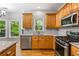 Bright kitchen with stainless appliances, stone countertops, tile backsplash, hardwood floors, and scenic views of trees at 7035 Hampton Bluff Way, Roswell, GA 30075