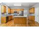 Spacious kitchen with stainless steel appliances, stone countertops, hardwood floors, and an island for easy meal preparation at 7035 Hampton Bluff Way, Roswell, GA 30075