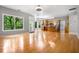 Open-concept living area featuring hardwood floors, a bank of windows, and a modern kitchen with stainless steel appliances at 7035 Hampton Bluff Way, Roswell, GA 30075