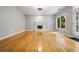 Bright living room with hardwood floors, cozy fireplace, and a door leading to outdoor space filled with light at 7035 Hampton Bluff Way, Roswell, GA 30075
