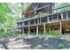 Exterior rear view of the home featuring a wooden deck and a forested backdrop at 975 Timber Lake Trl, Cumming, GA 30041