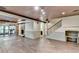 Open basement featuring wood floor, stone fireplace, textured ceiling, and access to kitchen at 975 Timber Lake Trl, Cumming, GA 30041