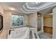 Luxurious bathroom with jacuzzi tub, elegant shower, and decorative window at 975 Timber Lake Trl, Cumming, GA 30041