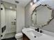 Modern bathroom featuring a glass-enclosed shower, ornate mirror and granite countertop sink at 975 Timber Lake Trl, Cumming, GA 30041