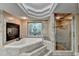 Luxurious bathroom featuring a jacuzzi tub, a fireplace, decorative window and a glass enclosed shower at 975 Timber Lake Trl, Cumming, GA 30041
