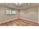 Bright bedroom with hardwood floors, trim detail, and a window providing natural light at 975 Timber Lake Trl, Cumming, GA 30041
