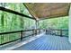 Open-air wooden deck with dark wood railings and lush greenery beyond at 975 Timber Lake Trl, Cumming, GA 30041