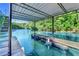 Covered dock with boat slips and ladders overlooking blue water surrounded by a lush, green forest at 975 Timber Lake Trl, Cumming, GA 30041