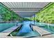 Covered dock showing boat slips with ladders and a metal roof, surrounded by trees at 975 Timber Lake Trl, Cumming, GA 30041