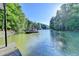 View of boat dock from a distance across calm water, with a forest in the background at 975 Timber Lake Trl, Cumming, GA 30041