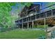 Large rustic home featuring a backyard deck, a large lawn, and a wooded lot at 975 Timber Lake Trl, Cumming, GA 30041