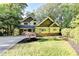 Landscaped front yard with a craftsman-style home featuring unique architectural details and lush trees at 975 Timber Lake Trl, Cumming, GA 30041