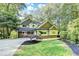 Craftsman-style home featuring a manicured lawn, stone accents, and lush greenery at 975 Timber Lake Trl, Cumming, GA 30041