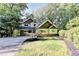 Well-maintained craftsman home with stone details and a manicured lawn, set amidst mature trees at 975 Timber Lake Trl, Cumming, GA 30041