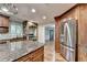 Kitchen features a center island with granite countertop and stainless steel refrigerator at 975 Timber Lake Trl, Cumming, GA 30041
