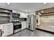 The kitchen has stainless steel appliances, white cabinets, and a view to a fireplace at 975 Timber Lake Trl, Cumming, GA 30041