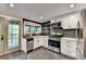 Modern kitchen features stainless steel appliances, white cabinetry, and an exterior door at 975 Timber Lake Trl, Cumming, GA 30041