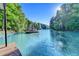 A scenic lake view showing a dock with a covered sundeck surrounded by green trees at 975 Timber Lake Trl, Cumming, GA 30041