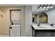 Bathroom and laundry room with stacked washer/dryer, double sink vanity with mirror at 975 Timber Lake Trl, Cumming, GA 30041