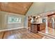 Open floor plan with hardwood floors, wood-paneled ceiling, and kitchen view at 975 Timber Lake Trl, Cumming, GA 30041