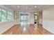 Open living room with hardwood floors, white trim, and French doors leading to another room at 975 Timber Lake Trl, Cumming, GA 30041