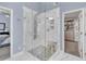 Modern bathroom featuring a glass-enclosed shower with multiple shower heads and a seat, adjacent to walk-in closet at 1420 Cortez Ne Ln, Atlanta, GA 30319