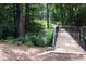 Scenic wooden bridge with black railings surrounded by lush greenery and tall trees at 1420 Cortez Ne Ln, Atlanta, GA 30319