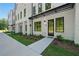 Exterior view of a white brick townhome featuring a black awning and dark-framed windows at 2202 Carlton Ct # 7, Atlanta, GA 30318