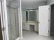 Bathroom with shower and vanity with white cabinets and drawers, ample lighting, and tile floor at 3118 Stanstead Ct, Norcross, GA 30071