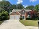 Charming two-story red brick home with a well-manicured lawn and a two-car garage at 3118 Stanstead Ct, Norcross, GA 30071