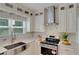 Bright kitchen with stainless steel appliances, white cabinets, and a large sink under the window at 1095 Lyndhurst Way, Roswell, GA 30075