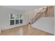 Bright living room with large window, hardwood floors, and staircase at 1095 Lyndhurst Way, Roswell, GA 30075