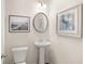 Bright powder room features a pedestal sink, modern fixtures and decorative wall art at 1328 Magnolia Bend Way # 289, Jonesboro, GA 30238
