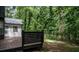 Large deck with black railings overlooks a private wooded backyard and a walking trail at 1930 Rocky Mill Ln, Lawrenceville, GA 30044