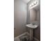 Clean, modern half-bathroom features pedestal sink, updated fixtures, and light grey paint at 1930 Rocky Mill Ln, Lawrenceville, GA 30044