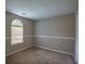 Bedroom featuring neutral carpeting, fresh paint and an arch-top window at 1930 Rocky Mill Ln, Lawrenceville, GA 30044